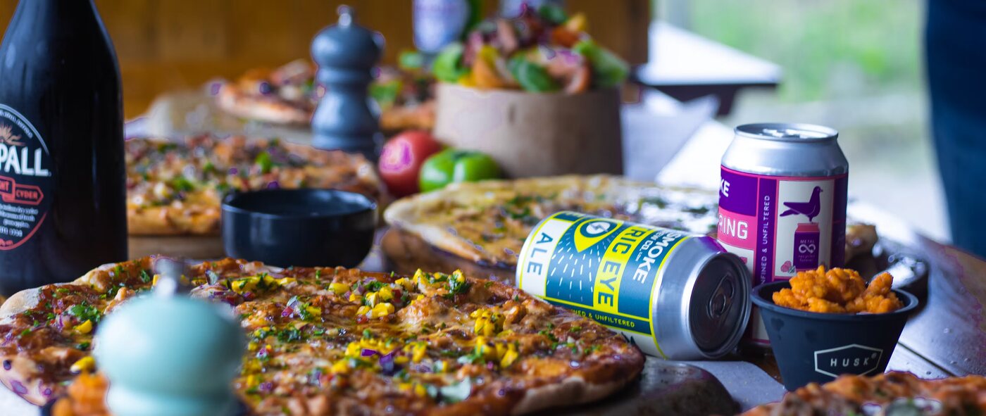 A spread of fresh pizzas and drinks laid out on a table