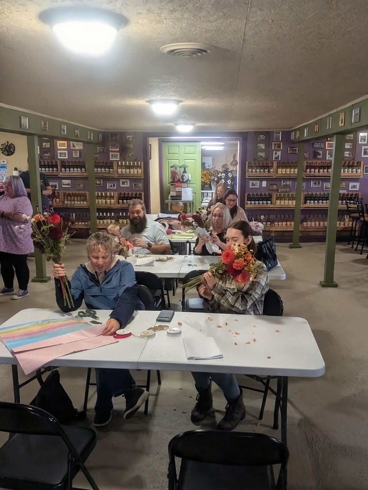 Guests at tables wrapping their finished bouquets in the winery tasting room