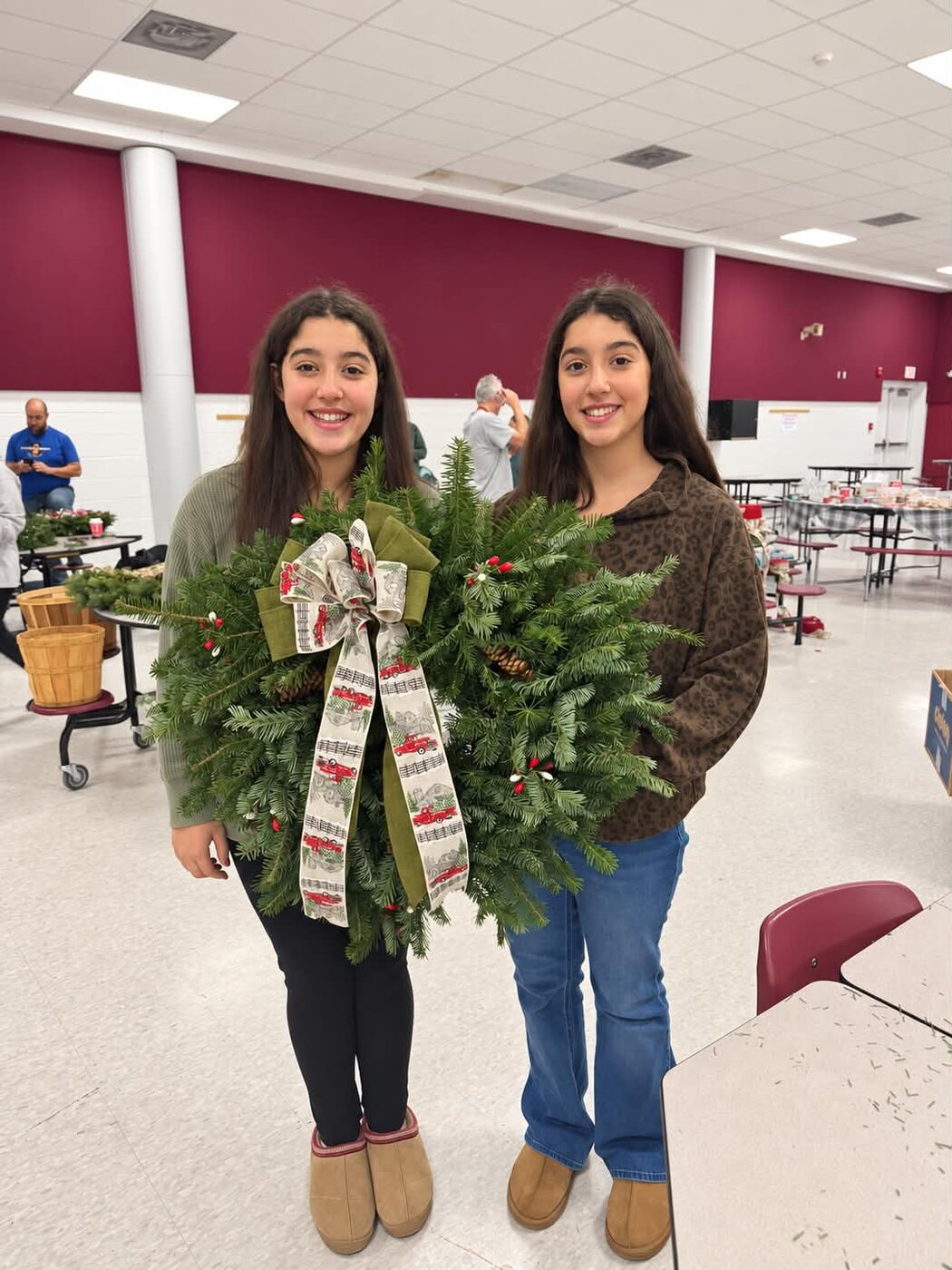 Two young volunteers holding the wreaths they made at the workshop