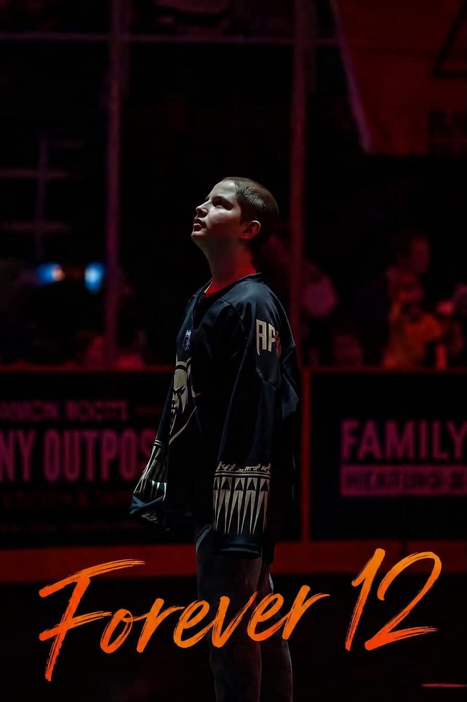 Lucas standing under the arena lights in his jersey, looking up, above the words Forever 12