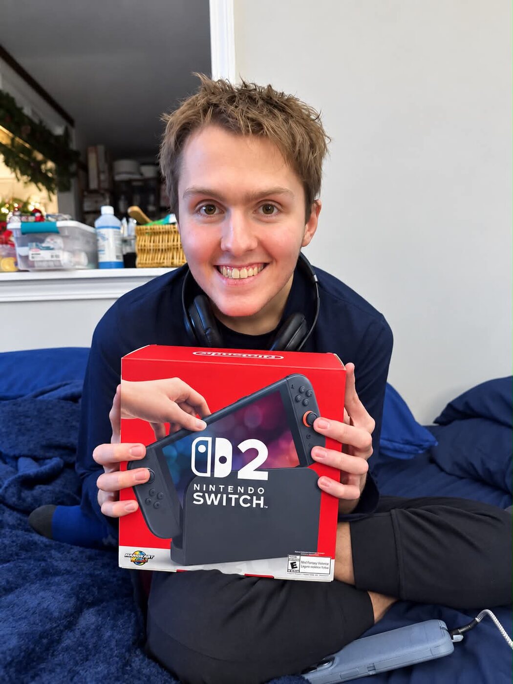 Hunter smiling and holding the Nintendo Switch 2 he received from his wish list