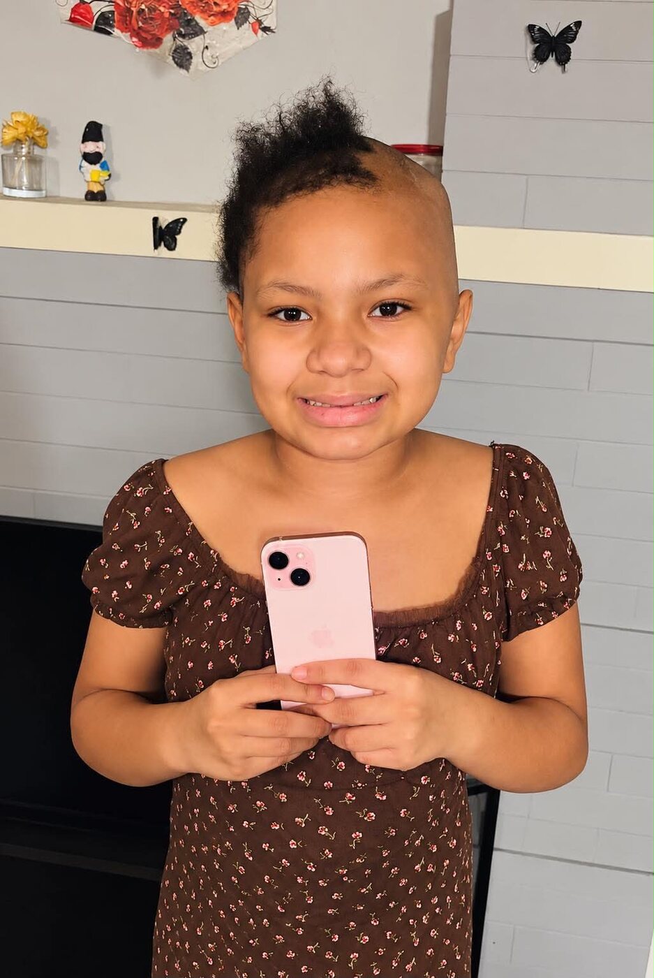 Jazzy smiling and holding the pink iPhone she received from her wish list