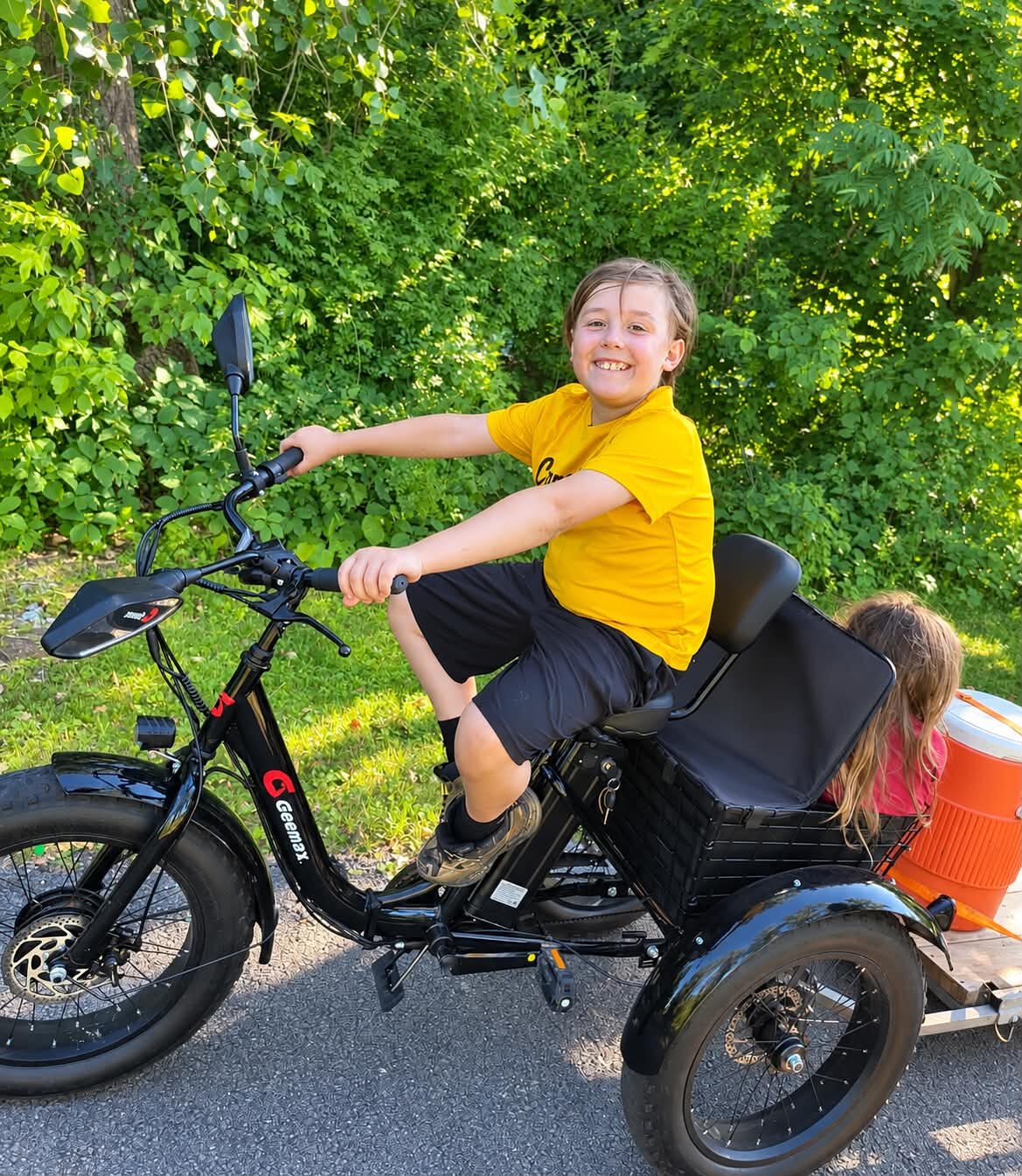 Bentley riding his new electric tricycle down the driveway