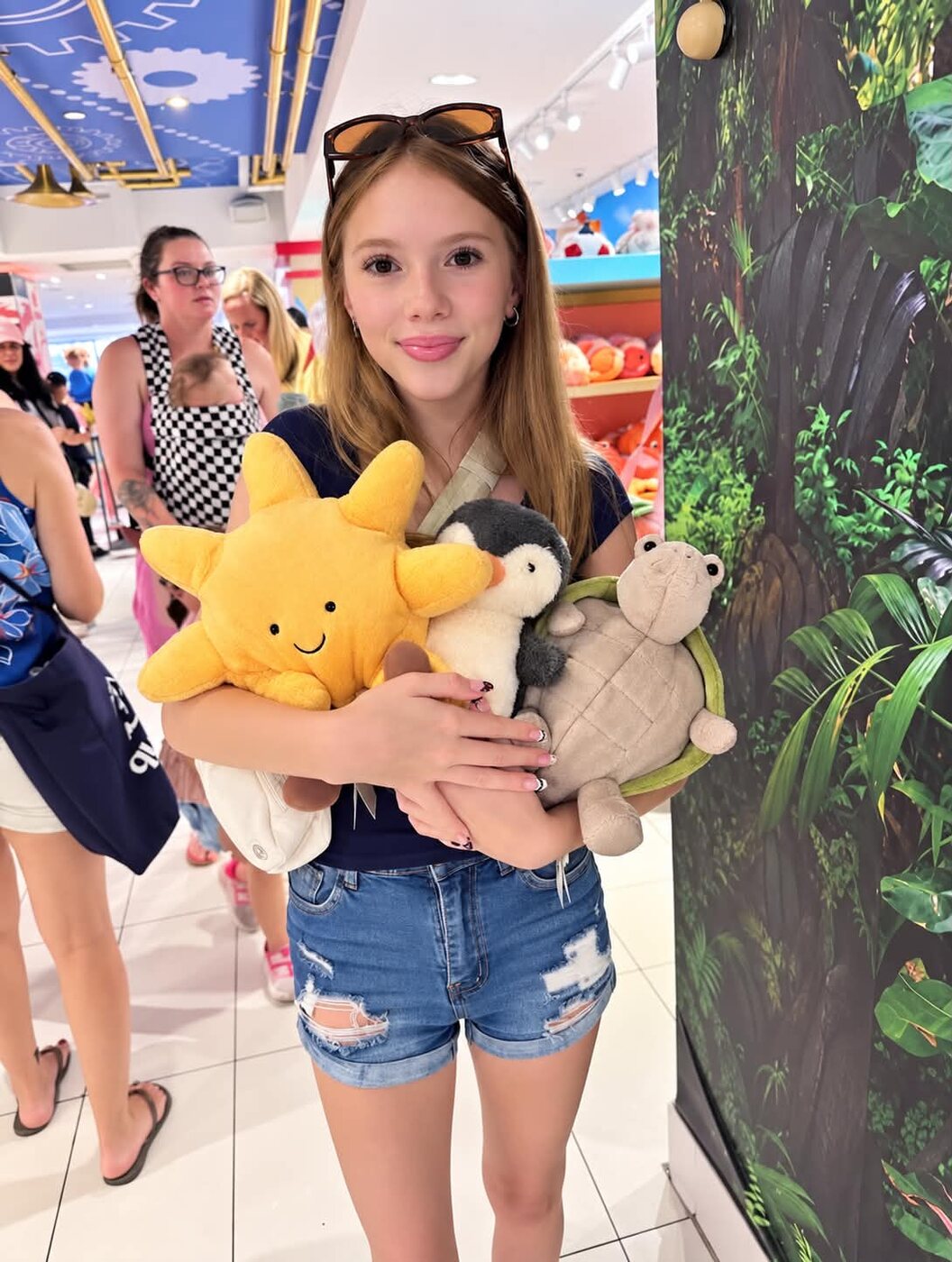 Olivia holding an armful of plush animals during her shopping spree